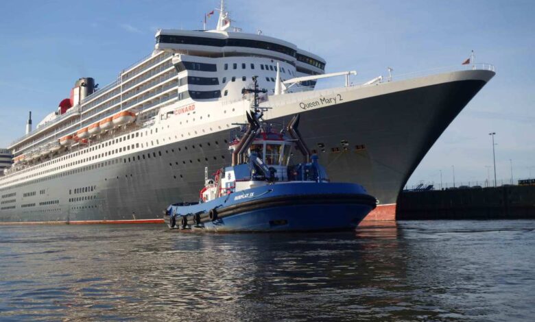 a boat in the water next to a large cruise ship