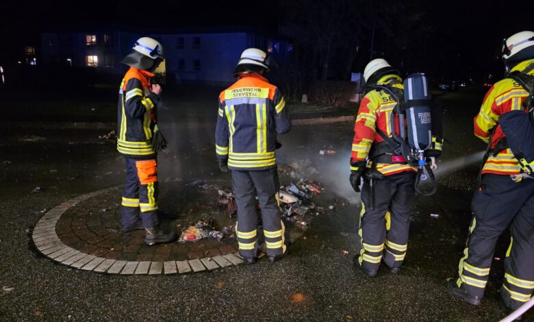 Feuerwehrleute um eine Brandstelle